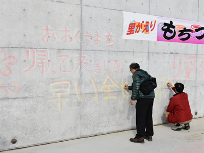 町民の方々による復興メッセージを描く様子（水張前の調整池壁面にて）